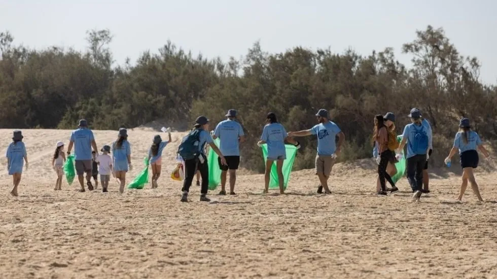 עובדי פיליפ מוריס מנקים בחוף ניצנים. צילום: ארז עזור