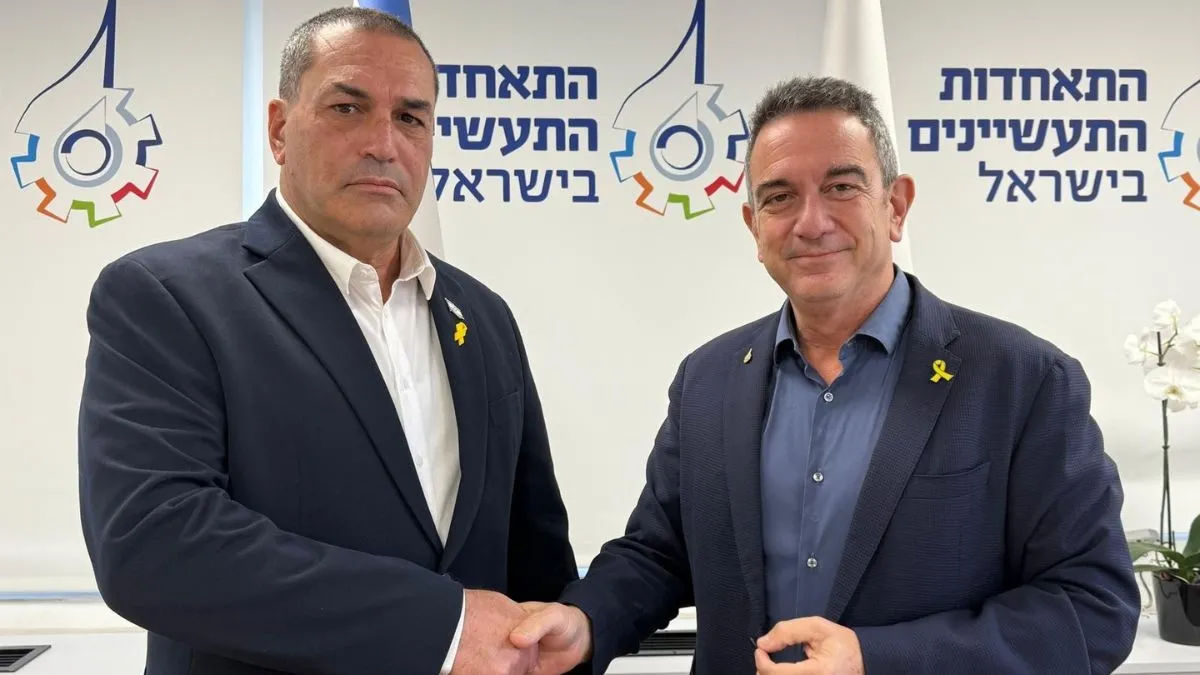 רון תומר, נשיא התאחדות התעשיינים, ואייל זמיר, מנכ״ל משרד הביטחון באסיפה הכללית של התעשיינים. צילום: אגף דוברות וקשרי ציבור במשרד הביטחון 