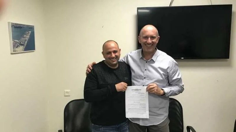 מוטי גדות ויניב ברוך עם ההסכם החתום. ברית בין העובדים וההנהלה